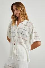 Camisa blanca de manga corta con botones en el frente, corte cuadrado y calce cómodo.