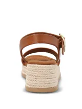 Sandalias Hush Puppies modelo Lili, color marrón, con plataforma de yute y suela de caucho. Presentan una tira ancha en el empeine y una correa ajustable al tobillo con hebilla metálica dorada.