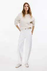 Pantalón jean de tiro alto en denim de algodón blanco, con diseño curvo de piernas con volumen y cinco bolsillos clásicos.