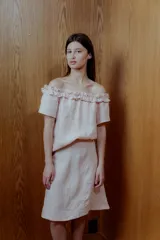 Blusa rosa de lino con escote off-shoulder y volados.