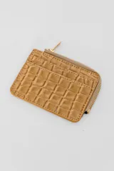 Monedero tarjetero color beige con textura símil cocodrilo y cierre de cremallera.