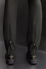 Pantalón de jogging negro confeccionado en tejido técnico ligero y elástico, corte slim fit, con cintura elástica ajustable con cordón, bolsillos laterales y trasero con cierre de cremallera, bandas reflectantes en las piernas y bajos ajustables con cremallera.