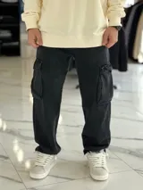 Pantalón cargo de jean negro, de corte oversize, con bolsillos laterales en las piernas y diseño amplio.