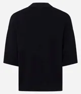 Blusa de punto de corte holgado, color negro, con cuello redondo elevado y mangas cortas amplias con sisa desplazada.