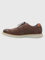 Zapato de estilo casual confeccionado en cuero marrón con detalles de perforaciones decorativas tipo brogue. Cuenta con cierre de cordones, forro interior de cuero y una suela de goma EVA ligera y flexible con tecnología Flex.