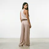 Pantalón de tela satinada color beige, de corte recto y tiro alto, con cintura elástica y cordón ajustable.