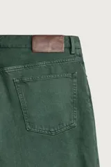 Jeans relaxed fit de algodón color verde oscuro, de tiro medio y pernera recta con raya de planchado. Cuenta con diseño de cinco bolsillos y cierre frontal con cremallera y botón.
