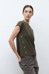 Remera de algodón color verde oliva, con cuello redondo, mangas cortas con dobladillo y detalle de botones laterales.
