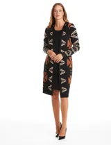 Vestido de punto con diseño integrado que simula un conjunto de vestido negro liso con un cárdigan largo estampado con patrón geométrico de eslabones. Presenta escote redondo y mangas largas.