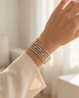 Esclava de acero con diseño calado y textura rugosa, decorada con pequeñas circonias incrustadas. El diseño simula múltiples aros superpuestos.