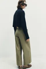 Pantalón culotte de tiro alto en color verde militar. Presenta bolsillos frontales de plastrón con solapa, cierre frontal con cremallera y botón, y diseño de pierna ancha con dobladillo marcado.