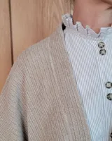 Ruana abierta de tejido de punto acanalado en color beige, con diseño holgado y caída fluida.