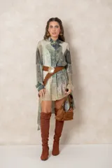 Cinturón trenzado de cuero sintético con acabado gamuzado, presenta una hebilla metálica circular grande con diseño ornamentado.