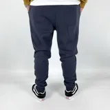 Pantalón de jogging azul marino con puños ajustados y logo bordado en dorado.
