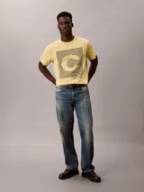 Remera Calvin Klein de manga corta y cuello redondo, color amarillo, con estampado gráfico frontal de líneas horizontales y la letra C en el centro.
