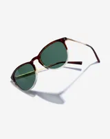 Lentes de sol Hawkers unisex, modelo Ollie. Marco de carey con borde inferior transparente, lentes verdes y patillas doradas.