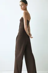 Pantalón sastrero de tiro alto y corte relajado con piernas amplias y pliegues frontales. Diseño a rayas finas.