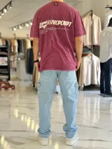 Remera oversize de color bordó con efecto gastado acid wash, mangas cortas y estampa en la espalda con texto y logo.