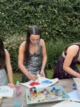 Vestido corto negro con estampado de plumas doradas, escote en V, breteles finos cruzados en la espalda, cut-outs laterales y volado en el ruedo.