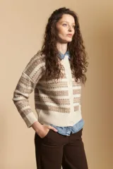 Cardigan corto de tejido jacquard con diseño geométrico en tonos beige y crema, con cierre frontal de botones y cuello redondo.