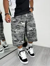 Bermuda ancha de jean con estampado camuflado en tonos de gris. Largo por debajo de la rodilla, estilo baggy.