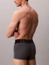 Pack de tres bóxers ajustados Calvin Klein de talle medio, confeccionados en mezcla de algodón y elastano. Incluye una unidad gris melange, una blanca y una azul, todas con cinturilla elástica negra distintiva de la marca.
