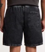 Bermuda de jeans de hombre, color negro con efecto desgastado o acid wash, de corte holgado. Posee cintura elástica con cordón de ajuste y bolsillos laterales.