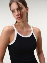 Musculosa nadadora de tela rib, color arena con ribetes en tono marrón oscuro en el cuello y las sisas, de corte ajustado al cuerpo.