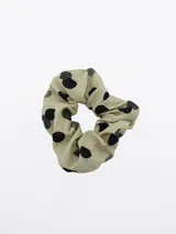 Colero para el pelo de color beige con estampado de lunares negros.