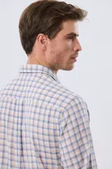 Camisa de lino con diseño a cuadros en tonos celestes y rosados, de manga larga, con cuello camisero, cierre frontal de botones y un bolsillo aplicado en el pecho con logo bordado.