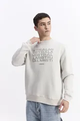 Buzo de algodón color marrón chocolate, con cuello redondo, mangas largas y estampa frontal con el nombre de la marca repetido en tono sobre tono.