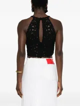 Top corto negro tejido a crochet con estampado floral, bordes festoneados y abertura en forma de lágrima.