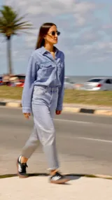 Camisa de jean celeste con cuello clásico, calce entallado, cierre frontal con botones metálicos y doble bolsillo con solapa abotonada en el pecho.