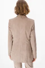 Blazer de corte clásico confeccionado en tela aterciopelada color bordó, con cuello solapa, cierre frontal con botones y bolsillos laterales tipo ojal.