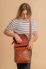 Bandolera de diseño simple con tapa frontal, confeccionada en material símil cuero. Cuenta con correa ajustable, división interna y bolsillos internos para mayor organización.