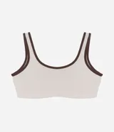 Top deportivo de microfibra con escote redondo delantero y escote en V en la espalda. Presenta un diseño bicolor con cuerpo en color crema y ribetes en color marrón oscuro, breteles anchos y copas desmontables.