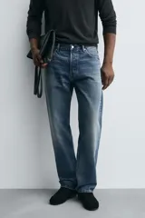 Jeans de corte recto en tono azul clásico con efecto lavado, tiro medio y diseño de cinco bolsillos con cierre frontal de botones.