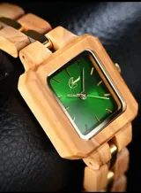 Reloj de pulsera con caja cuadrada de madera de olivo y esfera verde con marcadores minimalistas y agujas doradas. La malla es de madera de olivo con eslabones centrales metálicos en tono dorado.