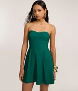 Vestido corto verde oscuro con escote corazón sin breteles, falda con pliegues delanteros y corte entallado en la cintura. Confeccionado en bengalina.