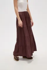 Falda larga de corte amplio con diseño de volados horizontales y cintura elástica, confeccionada en tejido de viscosa con textura arrugada.