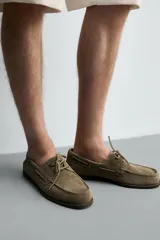Zapato náutico de hombre confeccionado en piel con acabado en serraje, color marrón claro, con detalles de cordones y ojales metálicos.