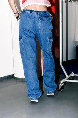 Pantalón jean cargo de tiro bajo, color celeste esfumado, con bolsillos cargo y pierna ancha.