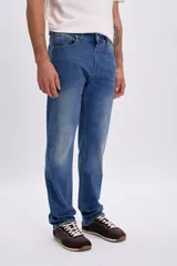 Pantalon jean de corte clasico en color azul medio, con diseño de tiro medio y cinco bolsillos.