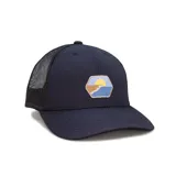 Gorra tipo trucker color negro con paneles traseros de malla y visera curva. Presenta un parche frontal hexagonal con un diseño gráfico de un paisaje de playa al atardecer.