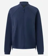 Campera deportiva de cuello alto con cierre frontal, mangas largas con puños elásticos y diseño de corte raglán. Presenta un estilo minimalista y funcional con cintura ajustable.
