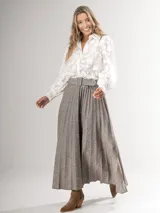 Falda larga marrón con diseño tableado y cinturón con hebilla forrada.