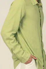 Camisa de manga larga color verde claro, confeccionada en tejido de lino y viscosa, con botones de madera y parche con logo.