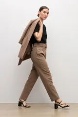 Pantalón sastrero color topo, de corte recto, con pinzas en la parte delantera y cinturón del mismo género con hebilla cuadrada.