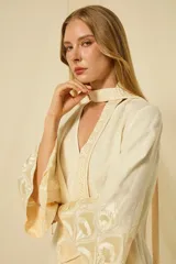 Minivestido blanco de lino con escote en V, mangas anchas acampanadas y bordados dorados en los puños, el dobladillo y el cinturón ajustable.