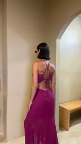 Vestido midi color uva con escote corazón, tirantes finos y aberturas laterales en la cintura. Presenta un diseño con frunces frontales y una falda con tajo lateral.